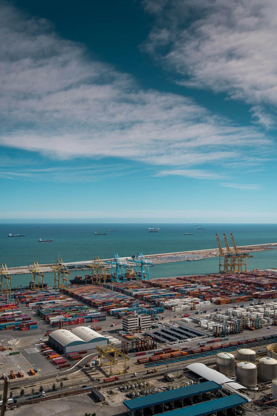Cargo ships and containers at a busy shipping port.